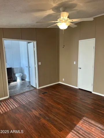 a view of a livingroom with a chandelier fan and wooden floor