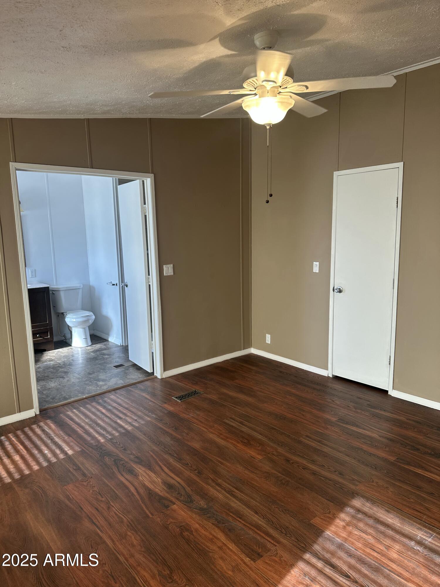 840 North Falton Road Maricopa, AZ 85139 - Photo 10 of 28 a view of a livingroom with a chandelier fan and wooden floor