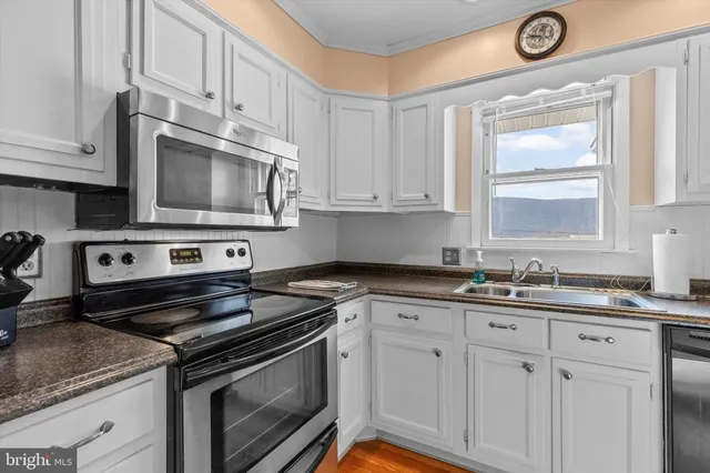 a kitchen with cabinets appliances a sink and a window