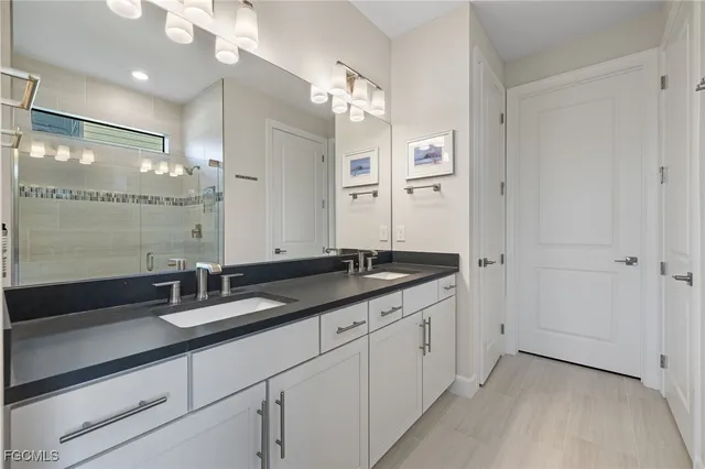 a bathroom with a granite countertop sink a large mirror and a shower