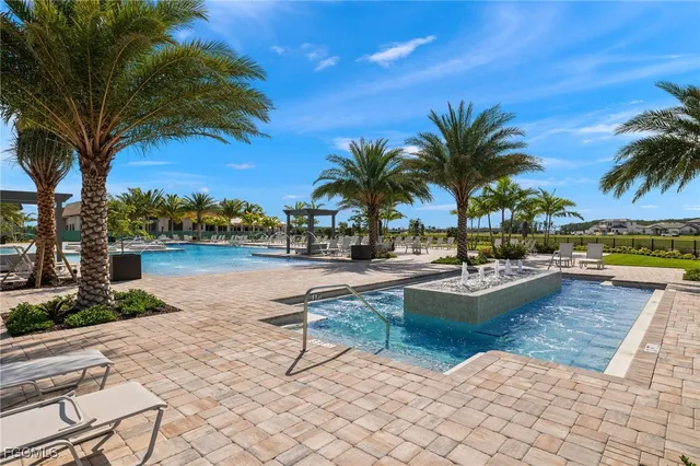 a view of swimming pool with table and chairs under an umbrella