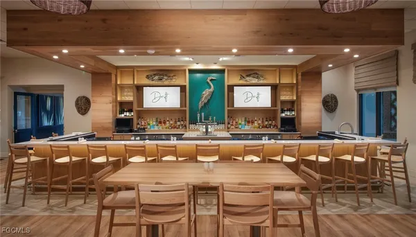 a large dining hall with stainless steel appliances a dining table and chairs