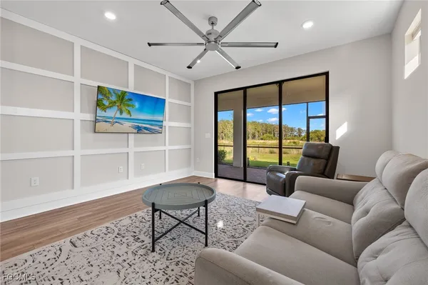a living room with furniture a ceiling fan and a rug
