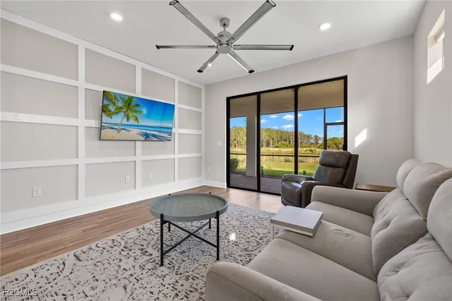 a living room with furniture a ceiling fan and a rug
