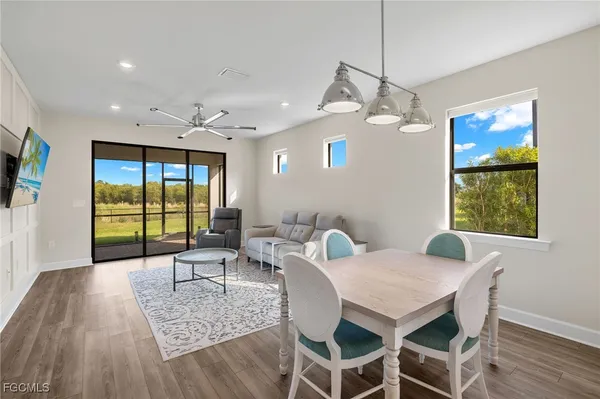 a dining room with furniture a chandelier and wooden floor
