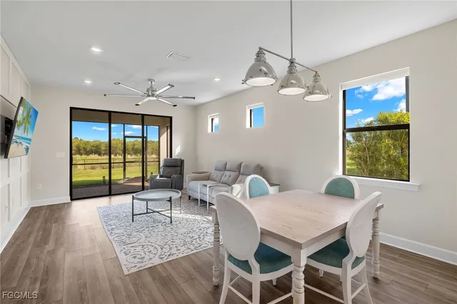 a dining room with furniture a chandelier and wooden floor