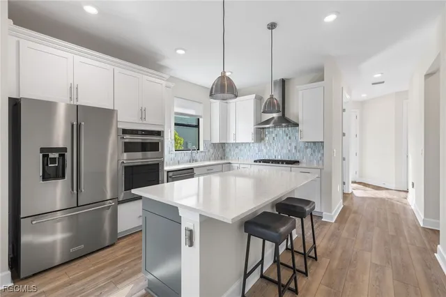 a kitchen with stainless steel appliances granite countertop a refrigerator a stove a sink and a refrigerator