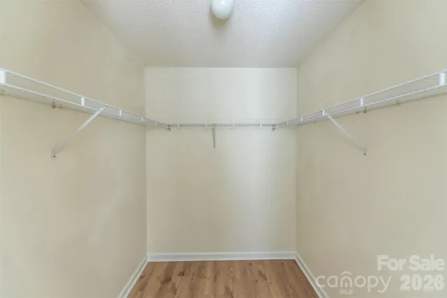 a view of walk in closet with clothes