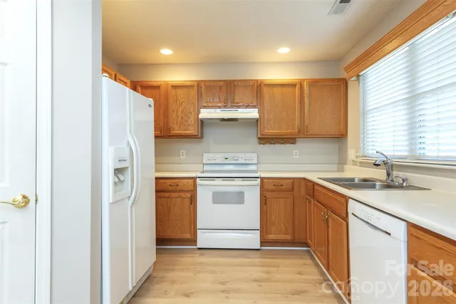 a kitchen with stainless steel appliances granite countertop a refrigerator and a sink