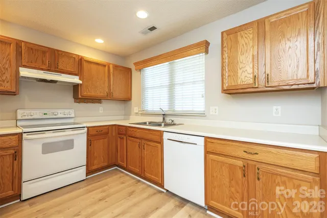 a kitchen with granite countertop cabinets stainless steel appliances and a sink