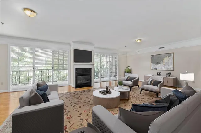 a living room with furniture a fireplace and a large window