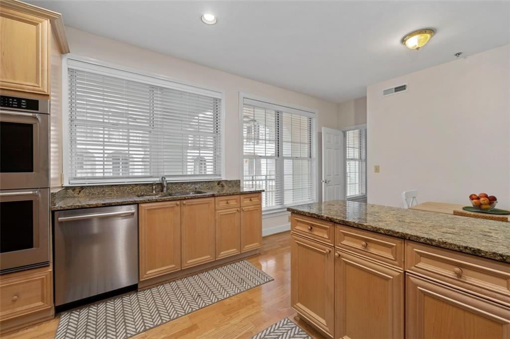 3101 Howell Mill Road Northwest, Unit 227 Atlanta, GA 30327 - Photo 11 of 48 a kitchen with stainless steel appliances granite countertop a sink and wooden cabinets