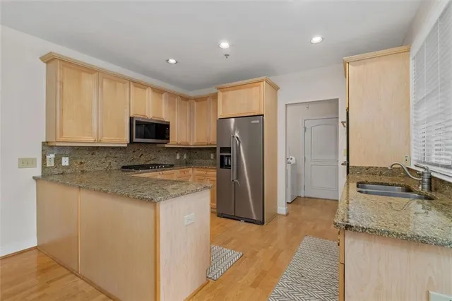 a kitchen with kitchen island granite countertop a sink stove and refrigerator
