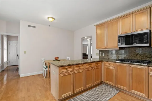 a kitchen with stainless steel appliances granite countertop a stove a sink and a microwave