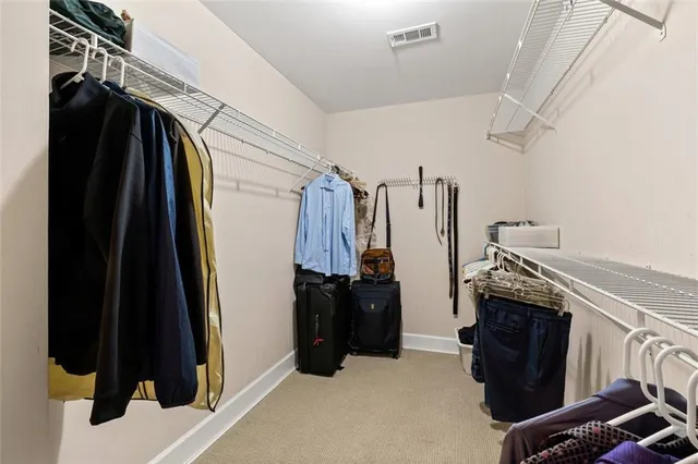 a view of walk in closet with clothes and shoes