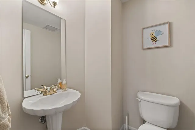 a bathroom with a toilet a sink and mirror