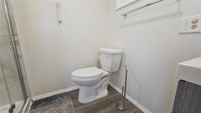 a white toilet sitting next to a shower