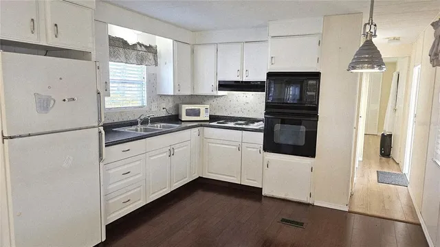 a kitchen with granite countertop white cabinets and white appliances