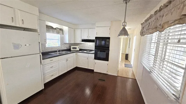 a kitchen with stainless steel appliances a refrigerator sink and microwave