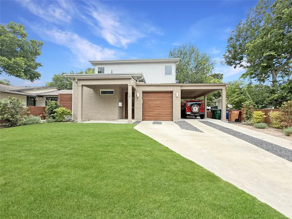 front view of a house with a yard and a garage