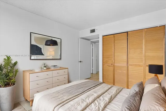 a bedroom with a bed and a potted plant