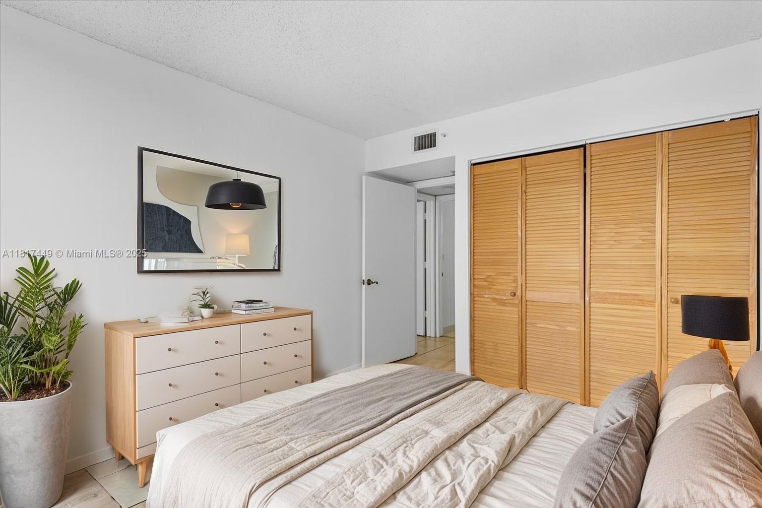 616 Northwest 26th Avenue, Unit 210 Miami, FL 33125 - Photo 8 of 23 a bedroom with a bed and a potted plant