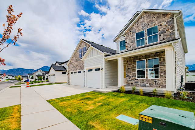 223 South Cottonwood Road, Unit 7501 Vineyard, UT 84059 - Photo 3 of 45 Contemporary stone and siding exterior featuring a covered porch with white columns, multiple large windows, and an attached two-car garage