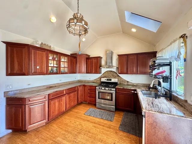 a kitchen with stainless steel appliances granite countertop a stove sink and cabinets