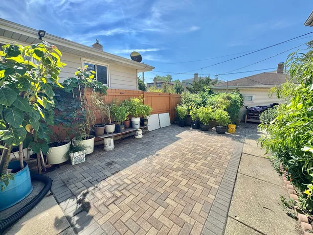 a view of a backyard with plants and chairs