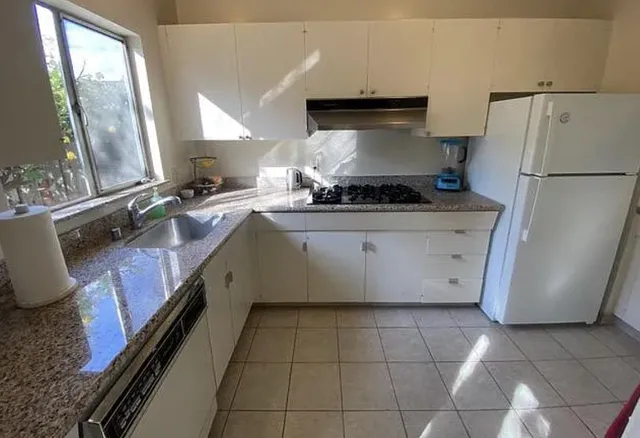 a kitchen with a stove top oven and refrigerator