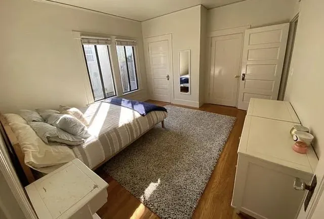 a bed sitting in a bedroom next to a window