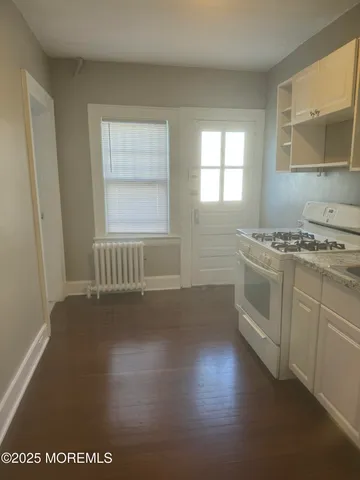 a kitchen with a stove a sink and a window