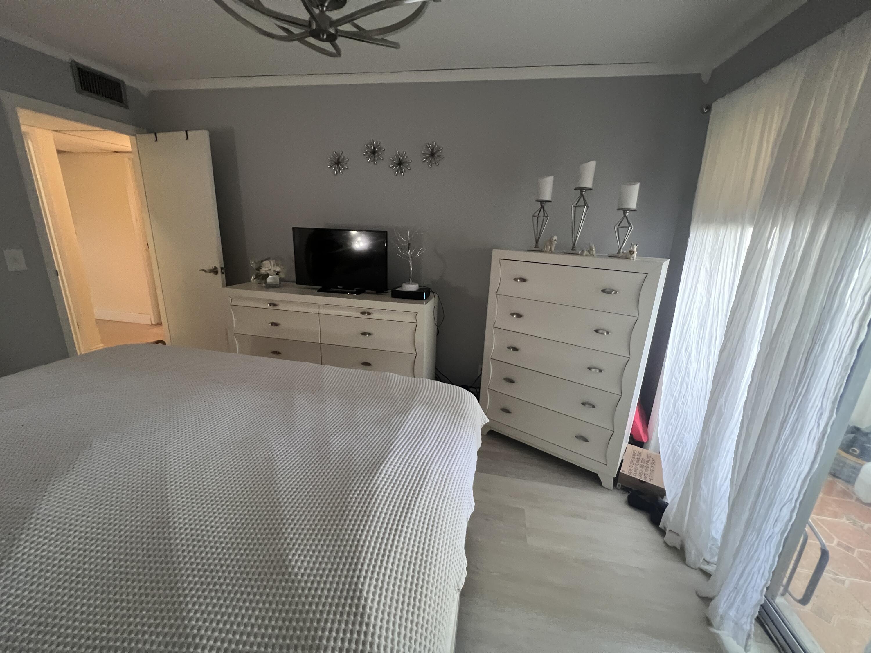 652 Flanders North Delray Beach, FL 33484 - Photo 17 of 27 a bedroom with a bed and a flat screen tv