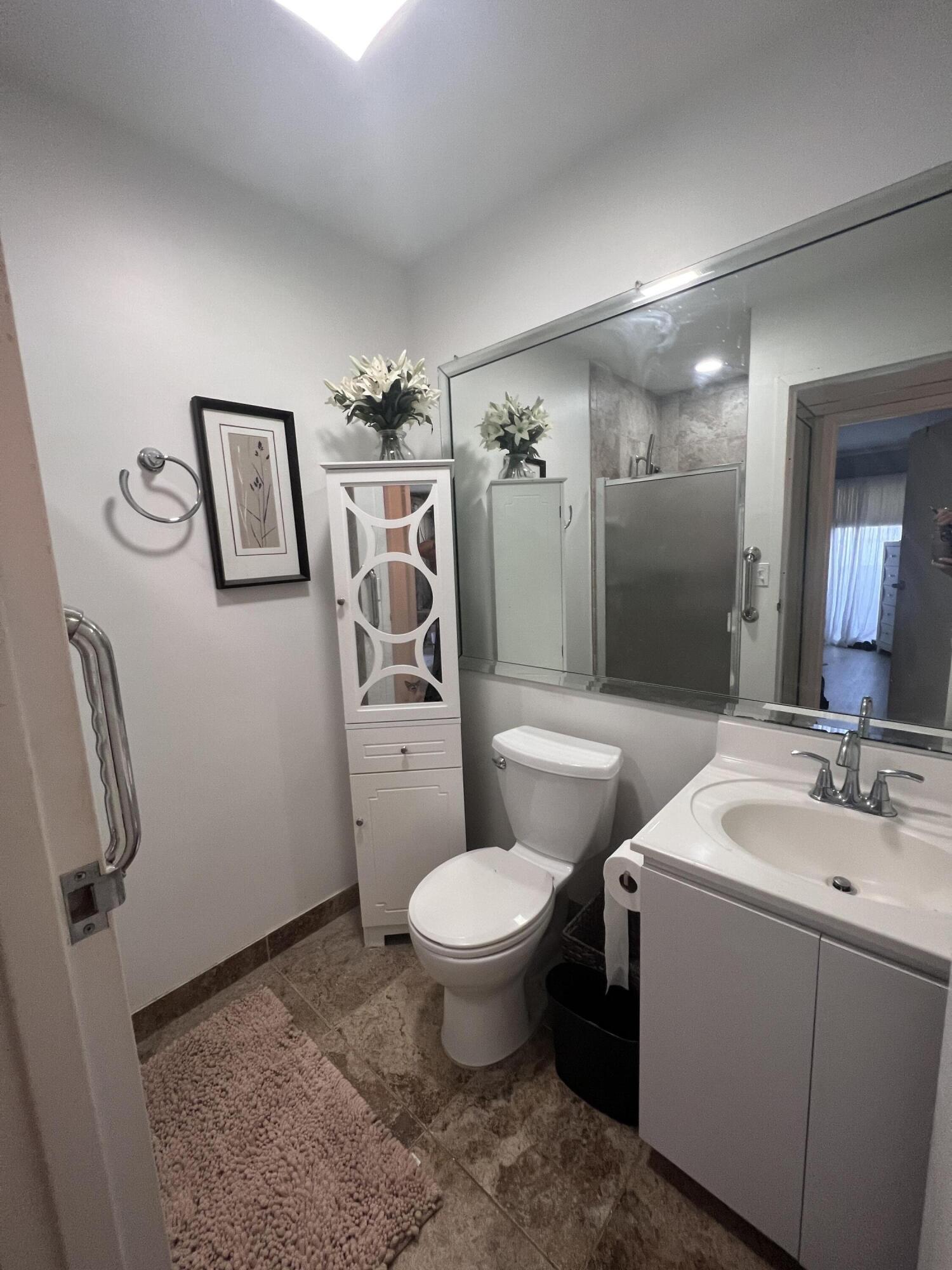 652 Flanders North Delray Beach, FL 33484 - Photo 18 of 27 a bathroom with a toilet sink and mirror