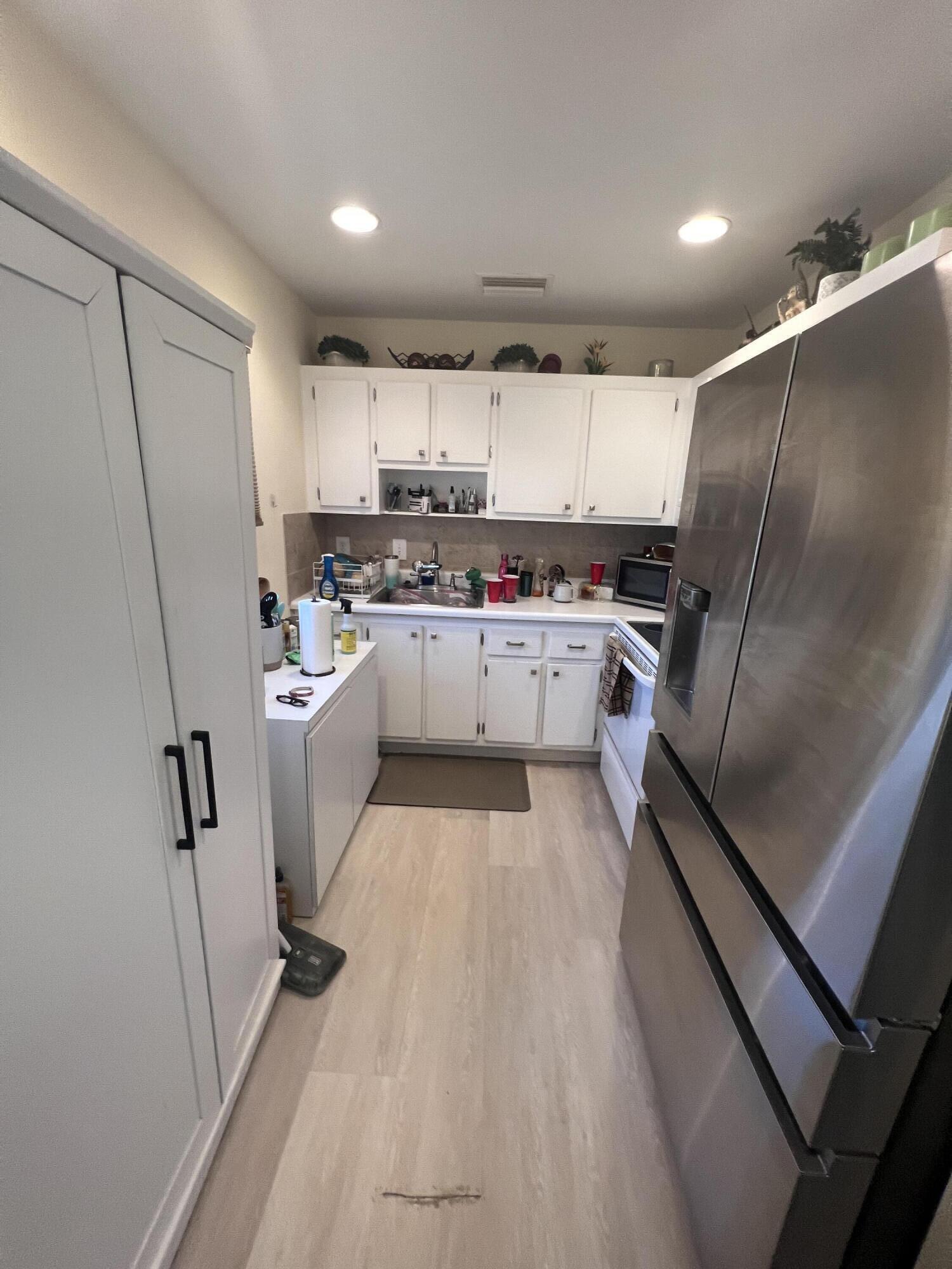 652 Flanders North Delray Beach, FL 33484 - Photo 6 of 27 a kitchen with refrigerator and white cabinets