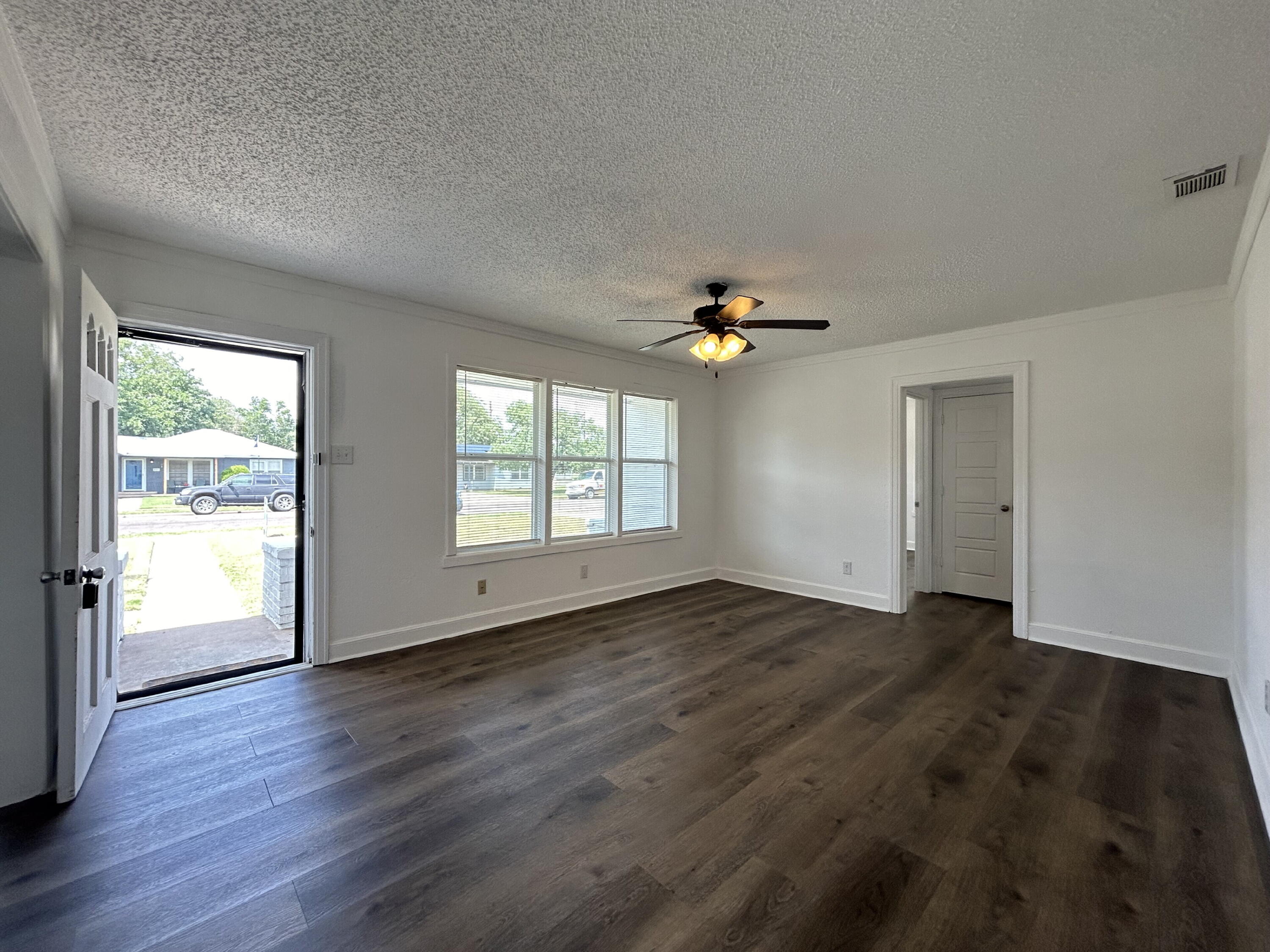 3005 31st Street Lubbock, TX 79410 - Photo 2 of 11 an empty room with wooden floor and windows