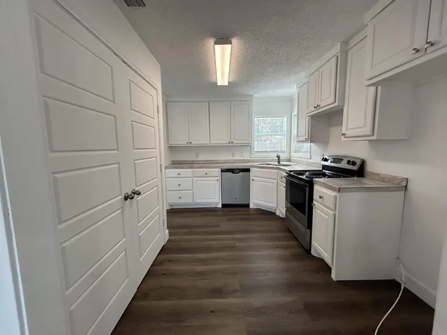 a kitchen with granite countertop a sink and cabinets