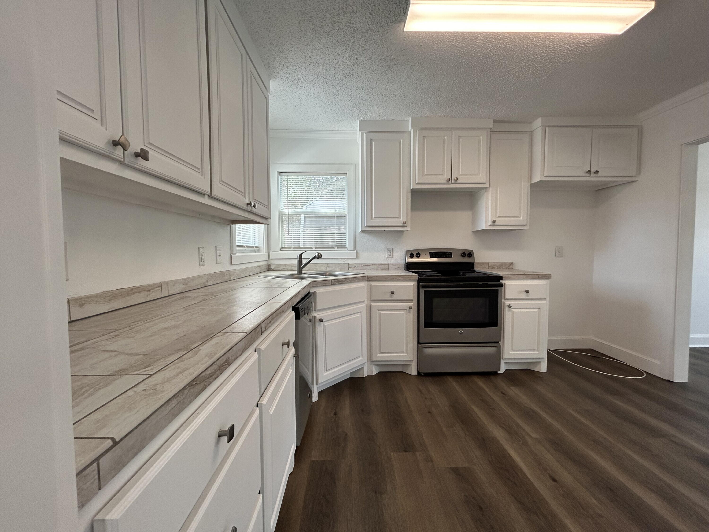 3005 31st Street Lubbock, TX 79410 - Photo 7 of 11 a kitchen with granite countertop white cabinets and appliances