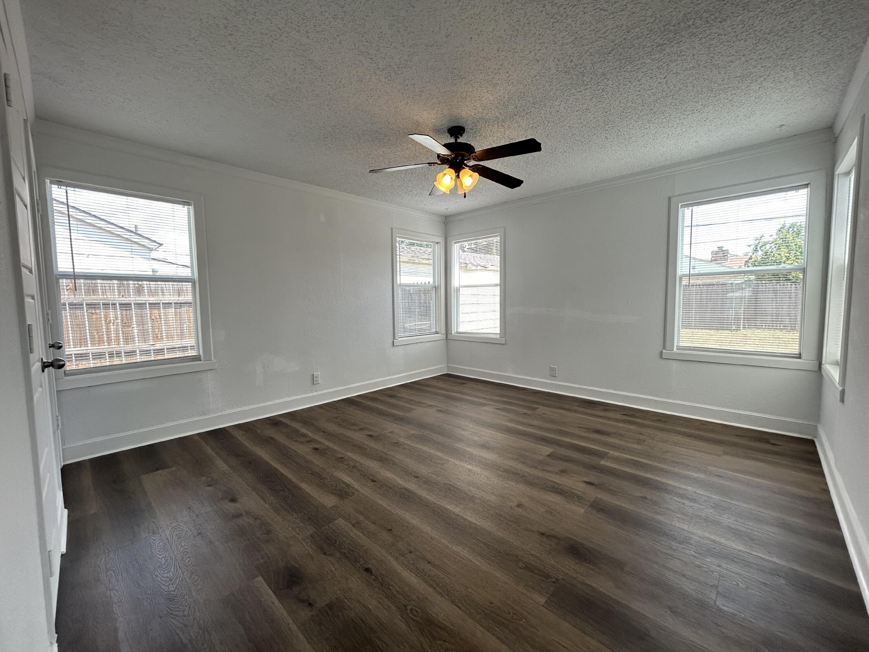 3005 31st Street Lubbock, TX 79410 - Photo 10 of 11 a view of empty room with wooden floor and fan