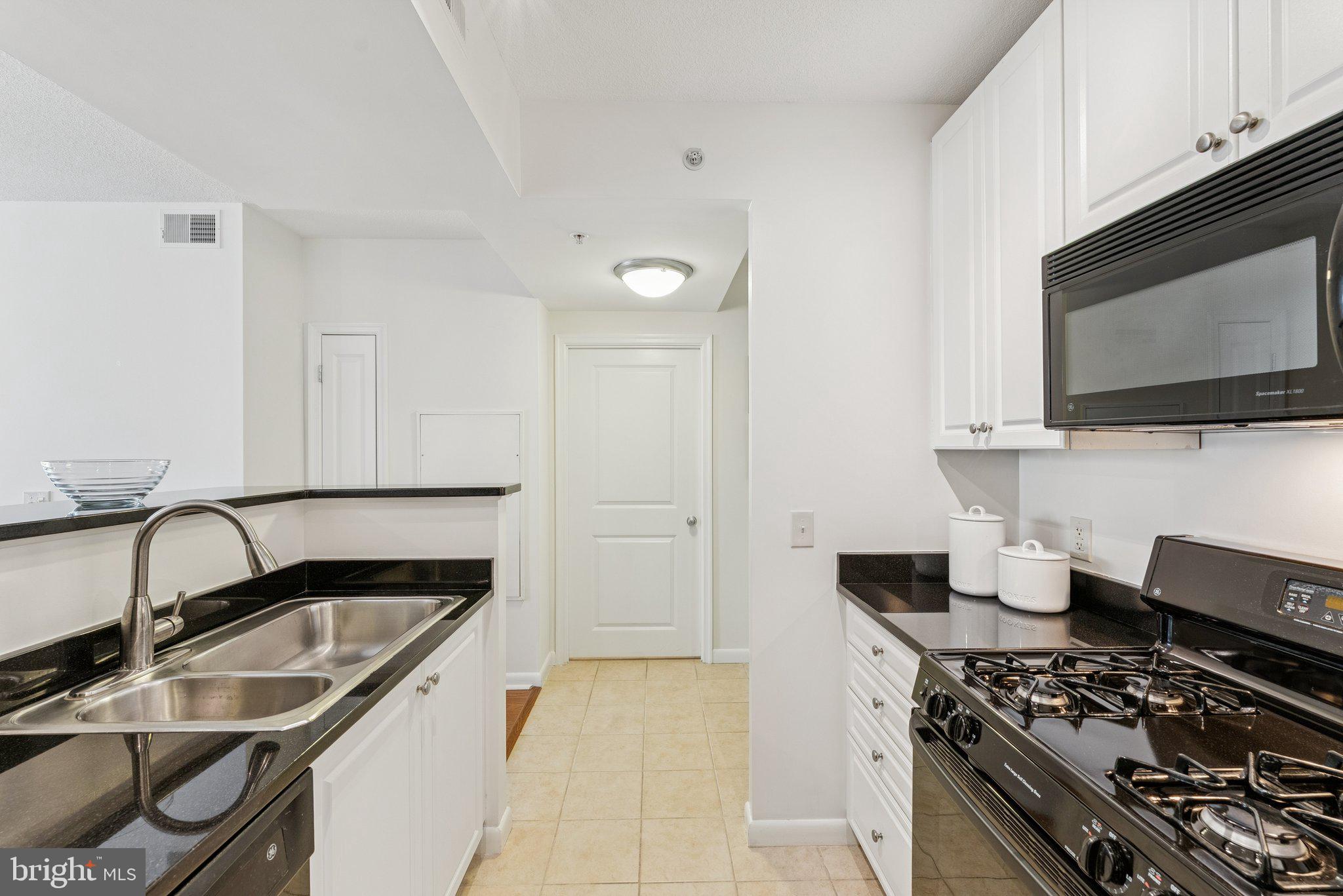 851 North Glebe Road, Unit 718 Arlington, VA 22203 - Photo 11 of 37 a kitchen with stainless steel appliances a stove a sink and a microwave