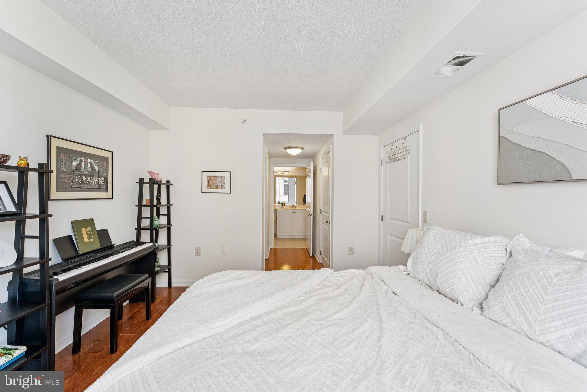 851 North Glebe Road, Unit 718 Arlington, VA 22203 - Photo 17 of 37 a bedroom with a bed and dresser with wooden floor