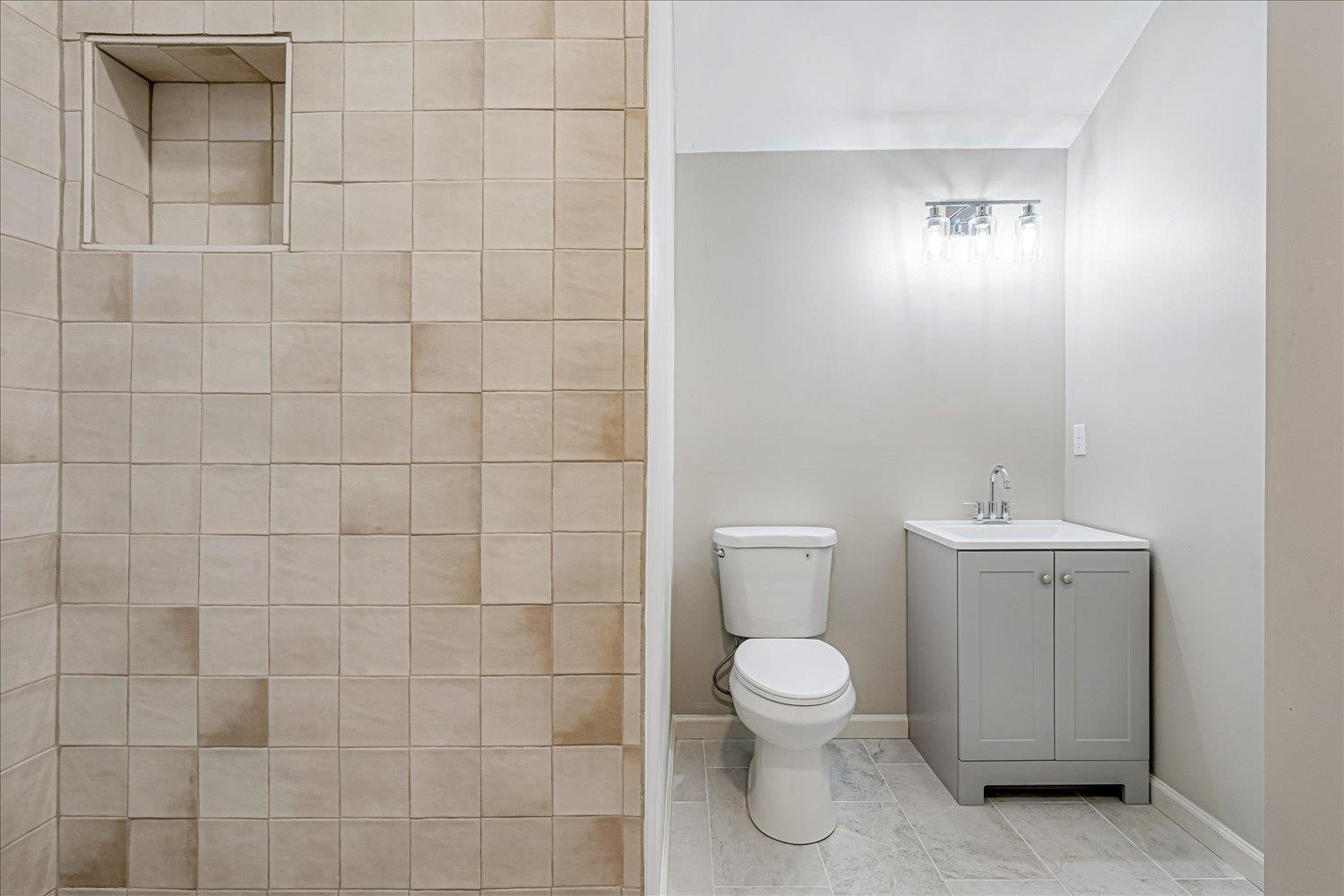 1069 Blythe Street Memphis, TN 38104 - Photo 17 of 24 Bathroom featuring vanity, a tile shower, and tile patterned flooring