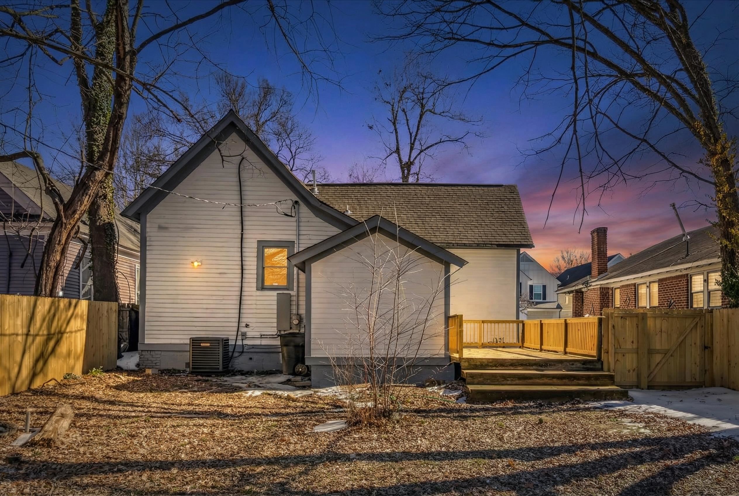 1069 Blythe Street Memphis, TN 38104 - Photo 24 of 24 Back of house at dusk with a gate, a wooden deck, and a shingled roof