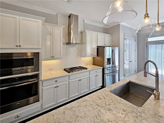 a kitchen with kitchen island a counter top space cabinets and stainless steel appliances