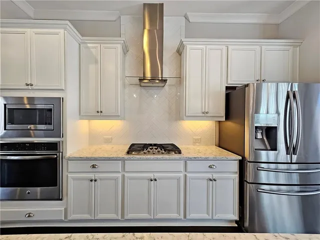 a large kitchen with a lot of counter space and wooden floor