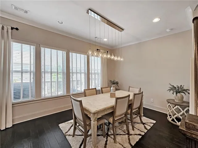 a view of a kitchen with kitchen island wooden floor center island and stainless steel appliances