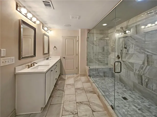 a spacious bathroom with a double vanity sink and mirror
