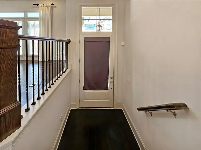 a view of a hallway with wooden floor and stairs