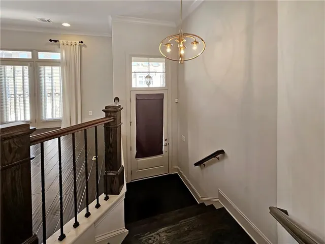 a view of a hallway with wooden floor and stairs