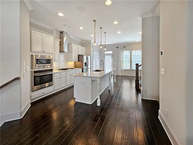a kitchen with wooden floors and appliances